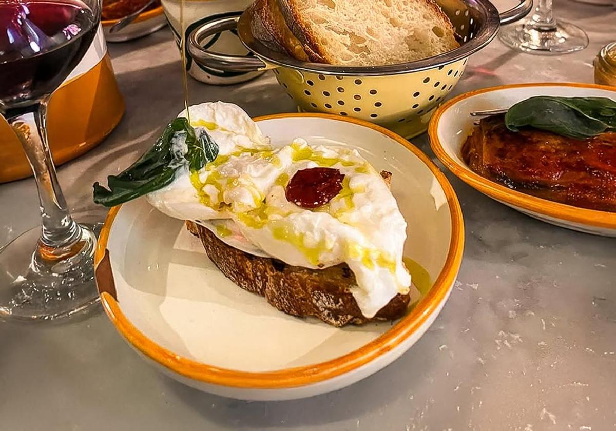 Milanese open-faced sandwich topped with egg and vegetables