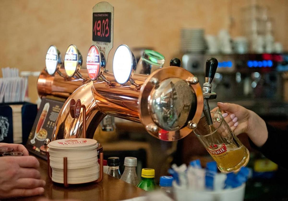 Bartender serving Polish beer from brass taps